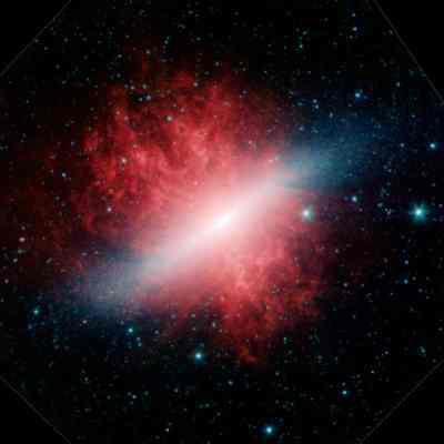 Infrared image from the Spitzer space telescope. The Cigar galaxy (blue) can be seen, surrounded by a giant halo of particles (red).
(Credits: NASA/JPL-Caltech/University of Arizona )