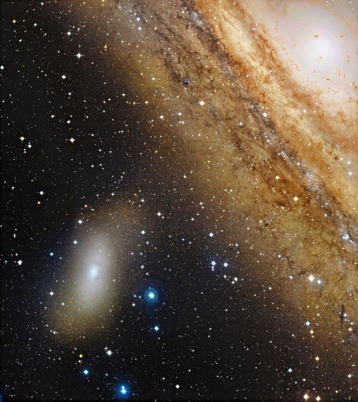 The M110 galaxy next to the imposing arms of M31, the great galaxy in Andromeda. Credit Canada-France-Hawaii Telescope